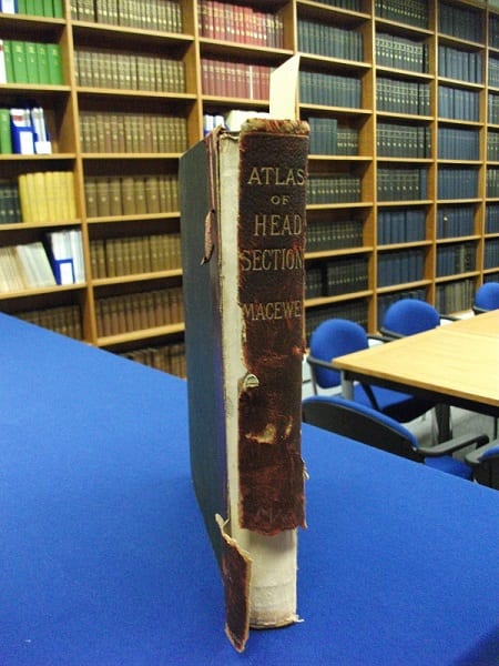 Damaged spine of "Atlas of head sections" by William Macewen